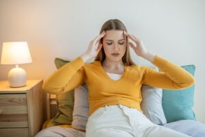 Woman in doctor’s office setting with eyes closed during Dialectical Behavior Therapy.