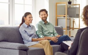 A man and woman sitting on a couch in couples therapy